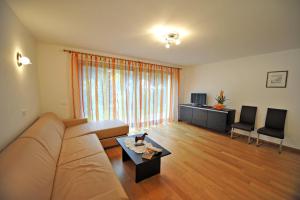un salon avec un canapé et une table dans l'établissement Apartments Villa Jim, à Ortisei
