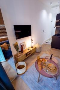 a living room with a table and a tv at Superbe studio balcon Plage/ Prom. des Anglais 103 in Nice