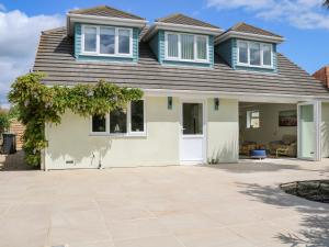 a house with a blue roof and a driveway at Wheatlands in South Hayling