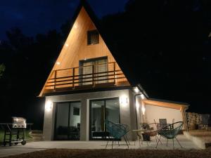 ein Haus mit einem dreieckigen Dach mit Stühlen drum herum in der Unterkunft Le Chalet de la Mûre in Bongheat