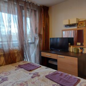Un dormitorio con una cama y una cómoda con televisión. en Комплекс Александьр между Банско и село Бяня, en Bansko