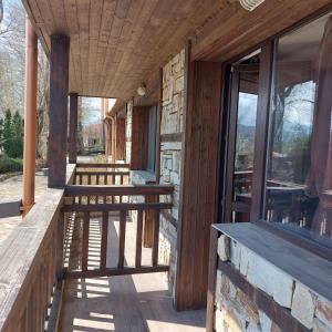 un porche de un edificio con bancos y ventanas en Комплекс Александьр между Банско и село Бяня, en Bansko