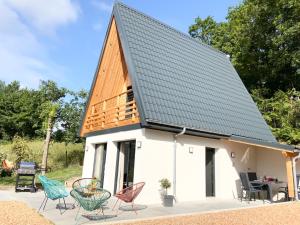 una casa con techo de metal y sillas en Le Chalet de la Mûre, en Bongheat