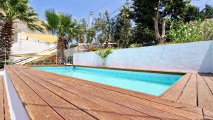 een zwembad met een houten terras naast een hek bij La piccola casa di Cinzia in Alcamo