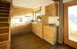 a kitchen with wooden cabinets and a window at Apartments Rondula in Santa Cristina Gherdëina