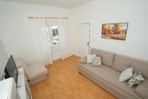 a living room with a couch and a television at Kuća za odmor Denona in Borovići