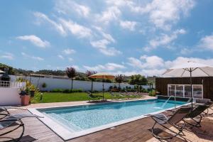 - une piscine avec des chaises et des parasols sur une terrasse dans l'établissement Barrocas Village, à Olho Marinho