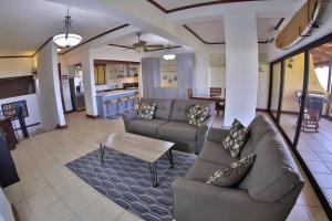 a living room with two couches and a table at Presidential Suites 4 - Recently renovated 2 bedroom condominium in the heart of Flamingo in Playa Flamingo