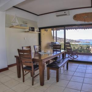 a dining room with a table and chairs and a balcony at Presidential Suites 4 - Recently renovated 2 bedroom condominium in the heart of Flamingo in Playa Flamingo