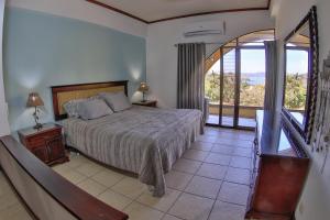a bedroom with a bed and a balcony at Presidential Suites 4 - Spacious condo in the heart of Flamingo, sleeps 6 in Playa Flamingo +50 photos