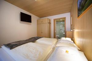 a bedroom with two beds and a tv on the wall at Apartments Miara in Santa Cristina in Val Gardena