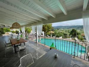 une terrasse avec une table, des chaises et une piscine dans l'établissement Borgo del Nespolo, à Peschici
