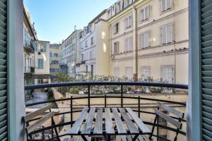 a wooden bench on a balcony with buildings at Place Massena - Beau 2P/Wifi - Vieux Nice/Plage in Nice