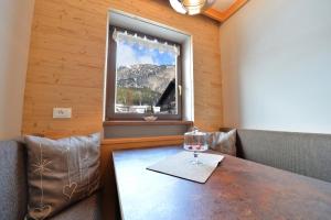 una sala da pranzo con tavolo e finestra di Apartment Nogler Frieda a Selva di Val Gardena