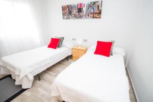 マラガにあるC70 - Classy 4 bedrooms Apartmentの赤い枕が備わる客室内のベッド2台