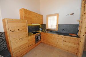a kitchen with wooden cabinets and a sink at Mountain Apartment Hapeli in Ortisei