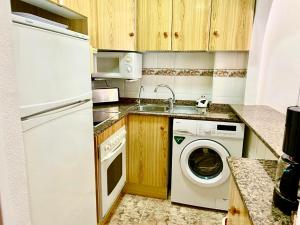 een keuken met een wastafel en een wasmachine bij DE VACACIONES in Torrevieja