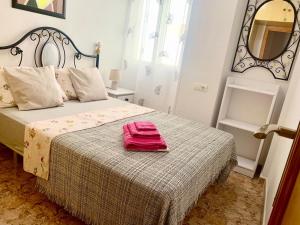 een slaapkamer met een bed met een roze handdoek erop bij DE VACACIONES in Torrevieja