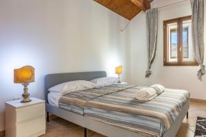 um quarto com uma cama, um candeeiro e uma janela em ConVivo Apartment em Lecce