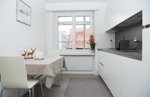 a white kitchen with a table and a window at Central flat Crapera-Lenzerheide in Lenzerheide