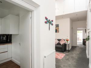 a kitchen and living room with white cabinets at Beeches Bach in Prestatyn