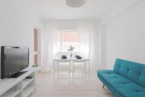 salon z niebieską kanapą i telewizorem w obiekcie C85 - Brand New 3 Bedroom Apartment by the Center w Maladze