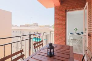 balkon z drewnianą ławką i stołem w obiekcie C85 - Brand New 3 Bedroom Apartment by the Center w Maladze