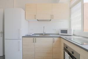 マラガにあるC85 - Brand New 3 Bedroom Apartment by the Centerの白いキッチン(シンク、電子レンジ付)