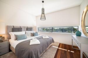 Un dormitorio con una cama grande y un espejo. en Apart L'Orange, en Vilamoura