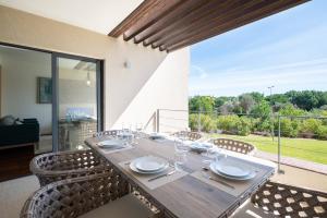 Una mesa de comedor con sillas y una gran ventana. en Apart L'Orange, en Vilamoura