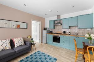 a living room with a couch and a kitchen at Albany by Black Door Stays in Cardiff