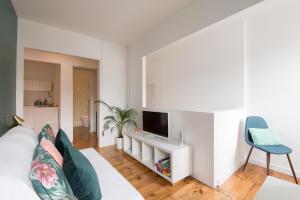 a living room with a couch and a tv and a chair at CASASUPERTUBOS - Peniche City Center in Peniche