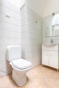 bagno bianco con servizi igienici e lavandino di ConVivo Apartment a Lecce