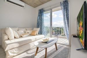 sala de estar con sofá blanco y ventana grande en A estrenar! Apartamento con pileta zona aeropuerto WIFI 200MG, en La Mercedes