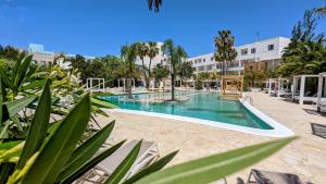 einen Pool in einem Resort mit Palmen in der Unterkunft The Palm Star Ibiza - Adults Only in Bucht von San Antonio