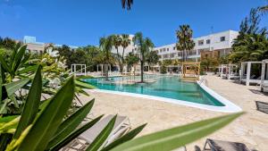 una piscina en un complejo con palmeras en The Palm Star Ibiza - Adults Only, en Bahía de San Antonio