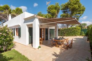 a white house with a patio with a table and chairs at CA'N MARC in Cala Blanca