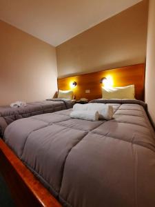 um quarto com duas camas com um urso de peluche deitado sobre ele em Hosteria Bello Horizonte em San Carlos de Bariloche