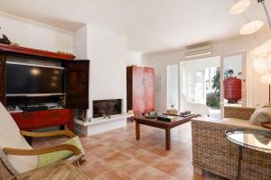 a living room with a couch and a tv at Villa Trebaluger in Trebeluger