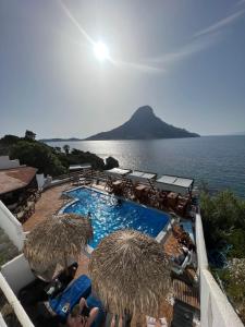 a swimming pool with umbrellas and a view of the ocean at Fatolitis Studios in Masouri