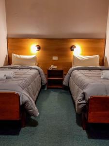 una habitación de hotel con 2 camas y un teléfono entre ellas en Hosteria Bello Horizonte en San Carlos de Bariloche