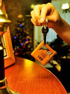 a person holding up a key to a table at Hosteria Bello Horizonte in San Carlos de Bariloche