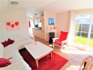 a living room with a couch and a table at Chalet 556 op Recreatiepark De Wielen in Sint Maarten