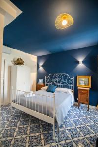 ein Schlafzimmer mit einem Bett und einer blauen Wand in der Unterkunft Crudo Home in Pompei