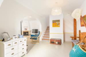 a living room with a white dresser and a staircase at Brisa Marina in Cala en Blanes