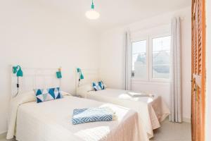 two beds in a white room with a window at Brisa Marina in Cala en Blanes +31 photos