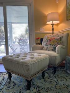 sala de estar con silla y reposapiés en Charming 1935 Florida Cottage overlooking Lake Tulane, en Avon Park