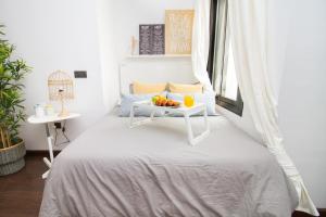 Un dormitorio con una cama con una mesa con fruta. en C77 - Romantic Studio in the Center with terrace, en Málaga