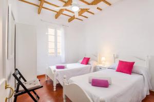 シウタデリャにあるCA S'AVI BIELの白い部屋のベッド2台 ピンクの枕付