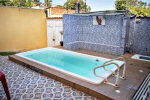 bañera en un patio con pared de ladrillo en Casa com Churrasqueira e Piscina em Camacari BA, en Camassari